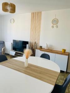 a living room with a table with a vase on it at 2 chambres dans Appartement cozy in Rodez
