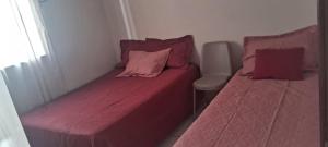 two beds with pink sheets in a small room at Conforto e Lazer no Coração da Ilha de São Luís in São-José-do-Ribamar +9 photos