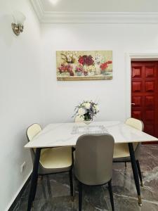 a dining room with a white table and chairs at Résidence Bethel in Libreville