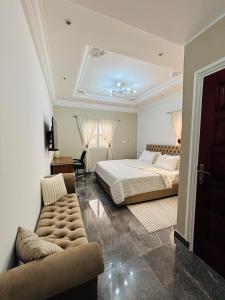 a bedroom with a bed and a couch at Résidence Bethel in Libreville