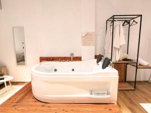a white bath tub sitting in a room at Jacuzzi Studio Room in Shkodër