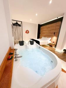 a large bath tub in a room with a bedroom at Jacuzzi Studio Room in Shkodër