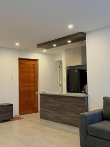 a living room with a couch and a kitchen at Departamento céntrico en estreno in Arequipa