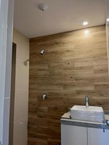 a bathroom with a sink and a wooden wall at Departamento céntrico en estreno in Arequipa +20 photos