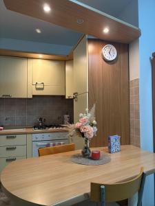 a kitchen with a table with a clock on the wall at Calvo in Ronchi dei Legionari