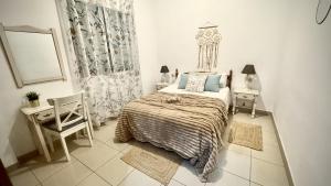 a bedroom with a bed and a table and a chair at Menendez Bohemian Dreams by Deihu Experiences in Los Cristianos