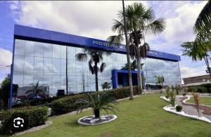 a large glass building with palm trees in front of it at Apartamento aconchegante in Ananindeua