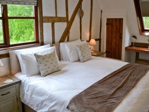 a large white bed in a room with windows at The Old Stables in Rickinghall +1 photo