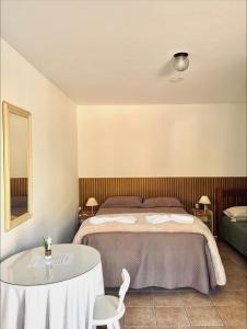 a bedroom with a bed and a table and chairs at Pousada Volare in Matinhos