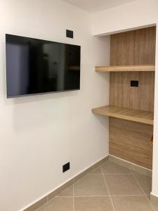 a living room with a tv on a white wall at Hotel Poblado Boutique in Medellín