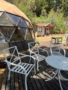 a group of chairs and a table on a deck at Tiny houses, domo en Temuco, Cumbres del Conunhuenu in Padre Las Casas