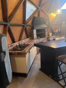 a kitchen with a stove and a counter top at Tiny houses, domo en Temuco, Cumbres del Conunhuenu in Padre Las Casas