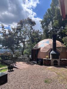 a large dome shaped building with a fireplace in a yard at Tiny houses, domo en Temuco, Cumbres del Conunhuenu in Padre Las Casas +14 photos