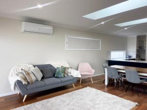 a living room with a couch and a table at Eliza's Escape 2 Wagga CBD in Wagga Wagga