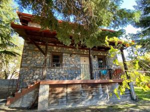 a stone house with a porch and a balcony at Elato Stone House in Panayítsa +14 photos