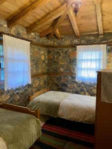 a bedroom with two beds in a log cabin at Elato Stone House in Panayítsa