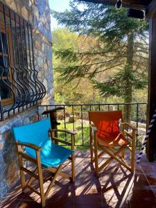 two chairs sitting on a porch with a view at Elato Stone House in Panayítsa