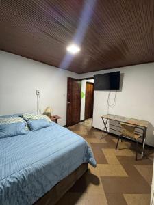 Un dormitorio con una cama, un televisor y una mesa. en Maca 7, en Bogotá