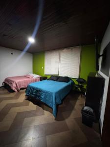 1 dormitorio con 2 camas en una habitación con paredes verdes en Maca 7, en Bogotá