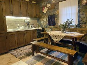 a kitchen with a table and benches in it at Elato Stone House in Panayítsa