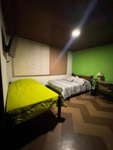 Habitación con cama y pared verde en Maca 7, en Bogotá