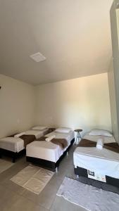 a group of three beds in a room at Hotel Fazenda Vitoria in Pindorama +2 photos