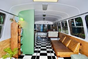 a train car with a couch and a checkered floor at Coffee Grounds - The Coach in Coffee Camp +15 photos