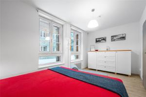a bedroom with a red bed and a dresser at Horní Mísečky - I3 Pohodlný a teplý apartmán u sjezdovky in Horni Misecky +10 photos