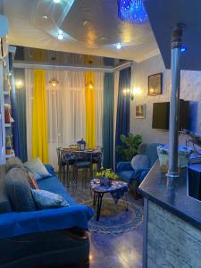 a living room with a blue couch and a table at Dea Apartments in Batumi