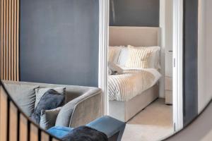 ein Spiegel, der ein Schlafzimmer mit einem Bett und einem Sofa reflektiert in der Unterkunft The Noir Suite - City Centre in Beeston Hill