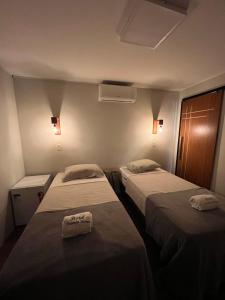 two beds in a small room with lights on at Hotel Fazenda Vitoria in Pindorama