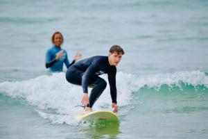 a young man riding a wave on a surfboard in the ocean at fulki house in Taghazout