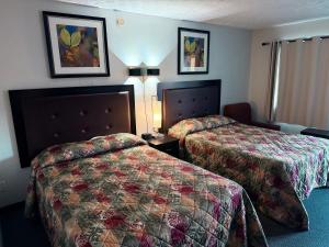 a hotel room with two beds and two lamps at Auberge Canadienne in Temiscaming