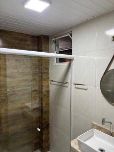 a bathroom with a shower and a sink and a mirror at Pousada Flor do Sol in Fortaleza