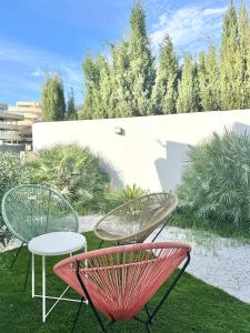 two chairs and a table and chairs on the grass at Boutique Higueron Spa in Fuengirola