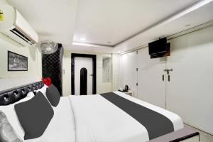 een slaapkamer met een zwart-wit bed en een televisie bij Super Hotel O Mani Bhai Patel in Kota +22 foto's