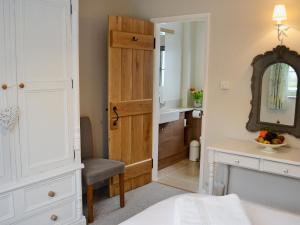 ein Schlafzimmer mit einem Bett, einem Waschtisch und einem Spiegel in der Unterkunft Cox Cottage - Pqqq in Pembury