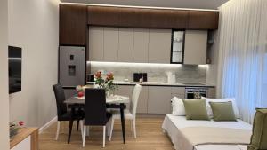 uma cozinha e sala de estar com uma mesa e um sofá em TheCozy Home Tirana em Sauk