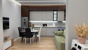 uma cozinha e sala de estar com uma mesa e um sofá em TheCozy Home Tirana em Sauk