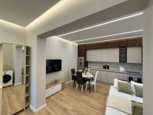uma sala de estar e cozinha com um sofá e uma mesa em TheCozy Home Tirana em Sauk