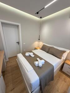 a bedroom with a large bed with two towels on it at TheCozy Home Tirana in Sauk
