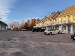 a parking lot with cars parked in front of a building at Auberge Canadienne in Temiscaming