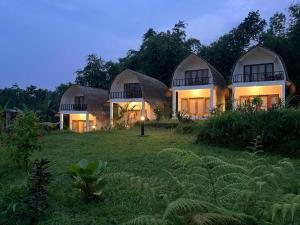 a house with a thatched roof in a field at Mimpi Manis Villas in Tetebatu +44 photos