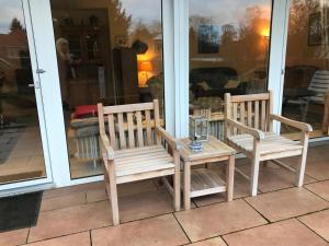 two wooden chairs and a table on a porch at Geschwister Kropp Zimmervermietung in Pattensen