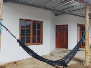 a hammock in front of a house with a door at Villa comoda in Puerto López
