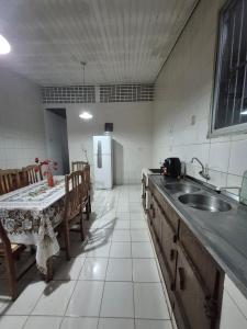 a kitchen with a table and a sink and a table and chairs at home in Belém cop 30 in Belém