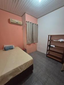 a bedroom with a bed and a book shelf at home in Belém cop 30 in Belém