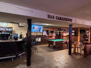 a bar with a pool table and a bar challenge sign at Auberge Canadienne in Temiscaming