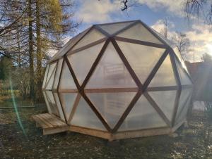 a large glass dome on a bench in a yard at Dome Backpackers hostel Ounasvaara in Rovaniemi