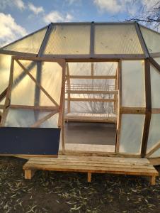a greenhouse with a glass roof on a wooden platform at Dome Backpackers hostel Ounasvaara in Rovaniemi +3 photos